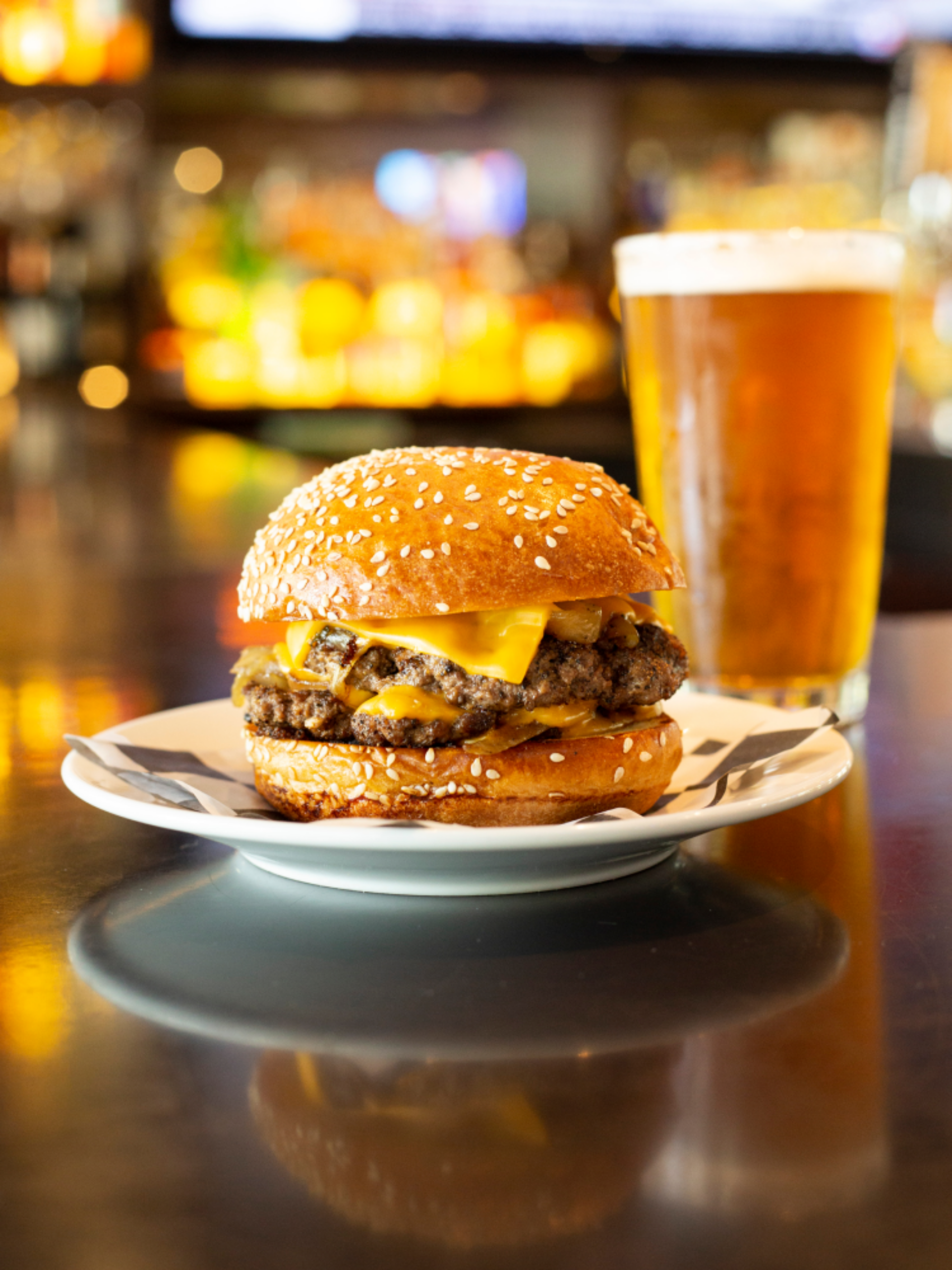 Burger on a plate with a beer in the background